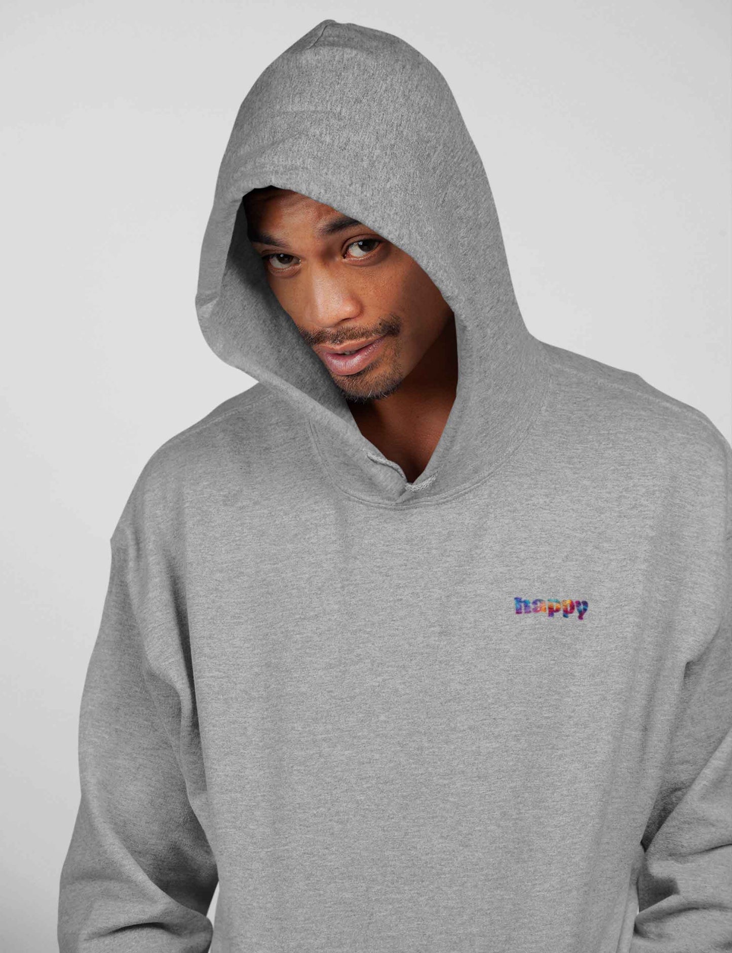 Lächelnder Mann mit grau meliertem Hoodie mit kleinem happy in bunten Farben auf der Front