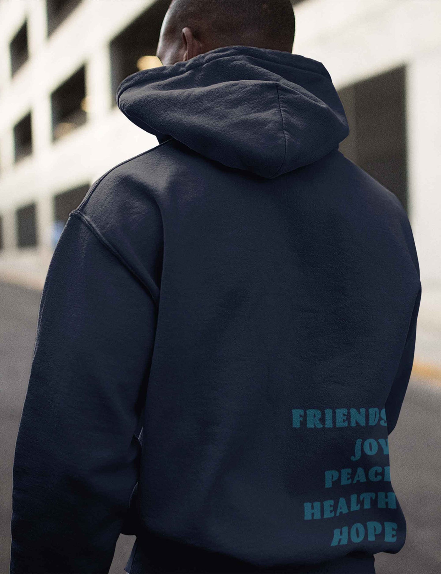 Mann mit navy farbenem Oversized Hoodie mit fünf Begriffen in Türkis auf dem Rücken