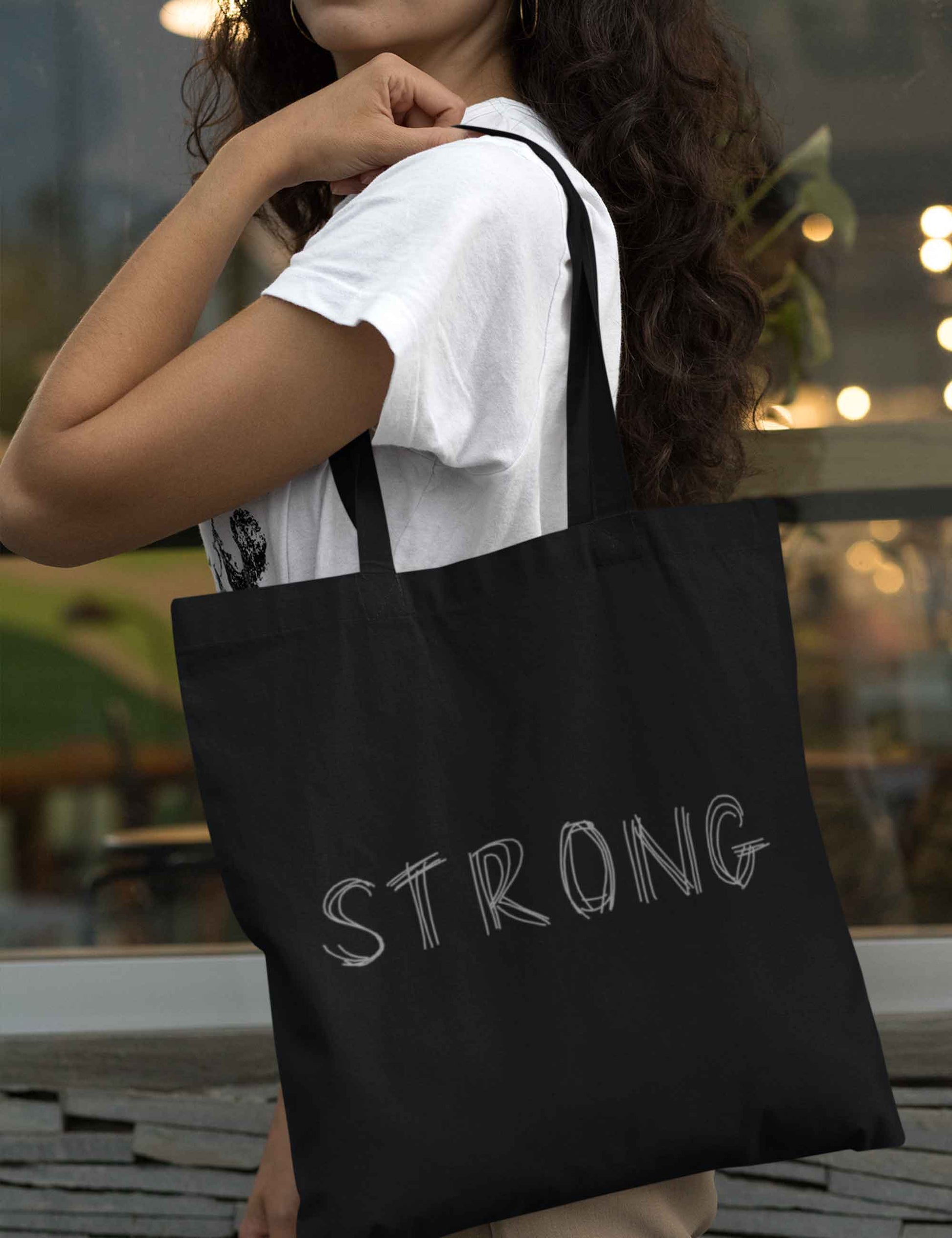 Fester Baumwollbeutel in Schwarz mit Bodenfalte, langen Henkeln zum besseren Tragen und natürlich einem stylischen Aufdruck: STRONG.