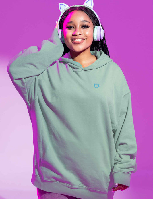 Frau mit lässigem mintfarbenen Hoodie mit kleinem, weichem Katzenkopf aus Flock