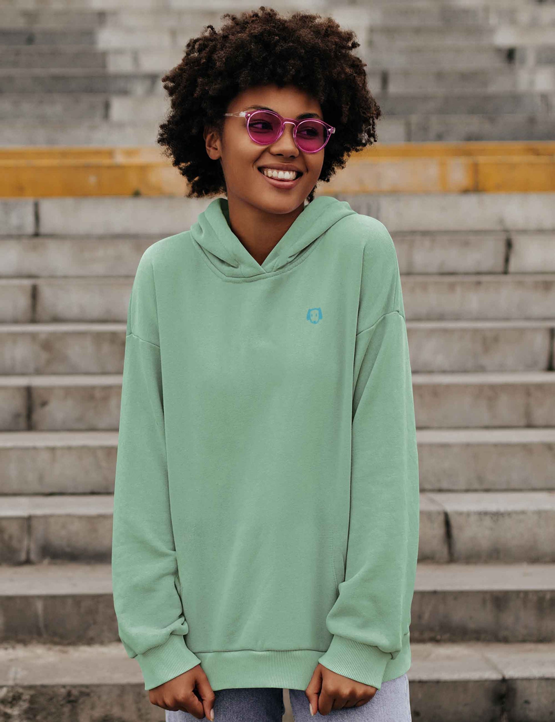 Frau mit mintfarbenem Hoodie mit kleinem, weichem Hundekopf aus Flock.