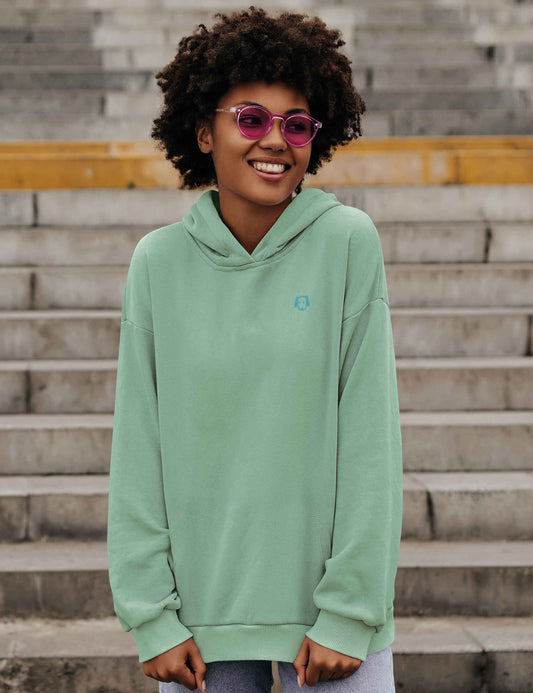 Frau mit mintfarbenem Hoodie mit kleinem, weichem Hundekopf aus Flock.