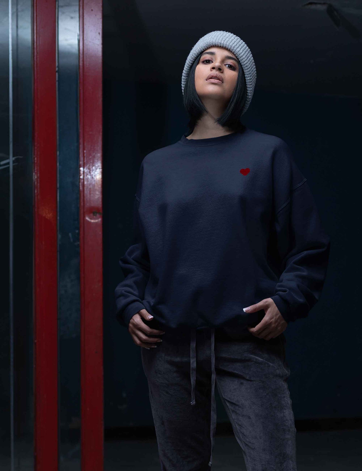 Frau mit navy farbenem Sweater mit kleinem, weichen Herzchen aus Flock auf der Brust