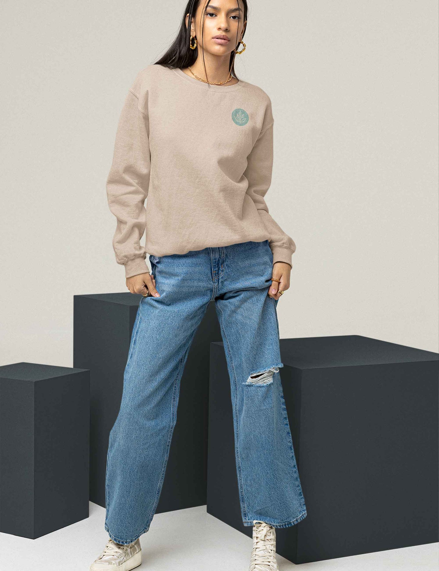 Frau trägt einen bequemen Oversized Sweater mit unserem Ray and Root Logo