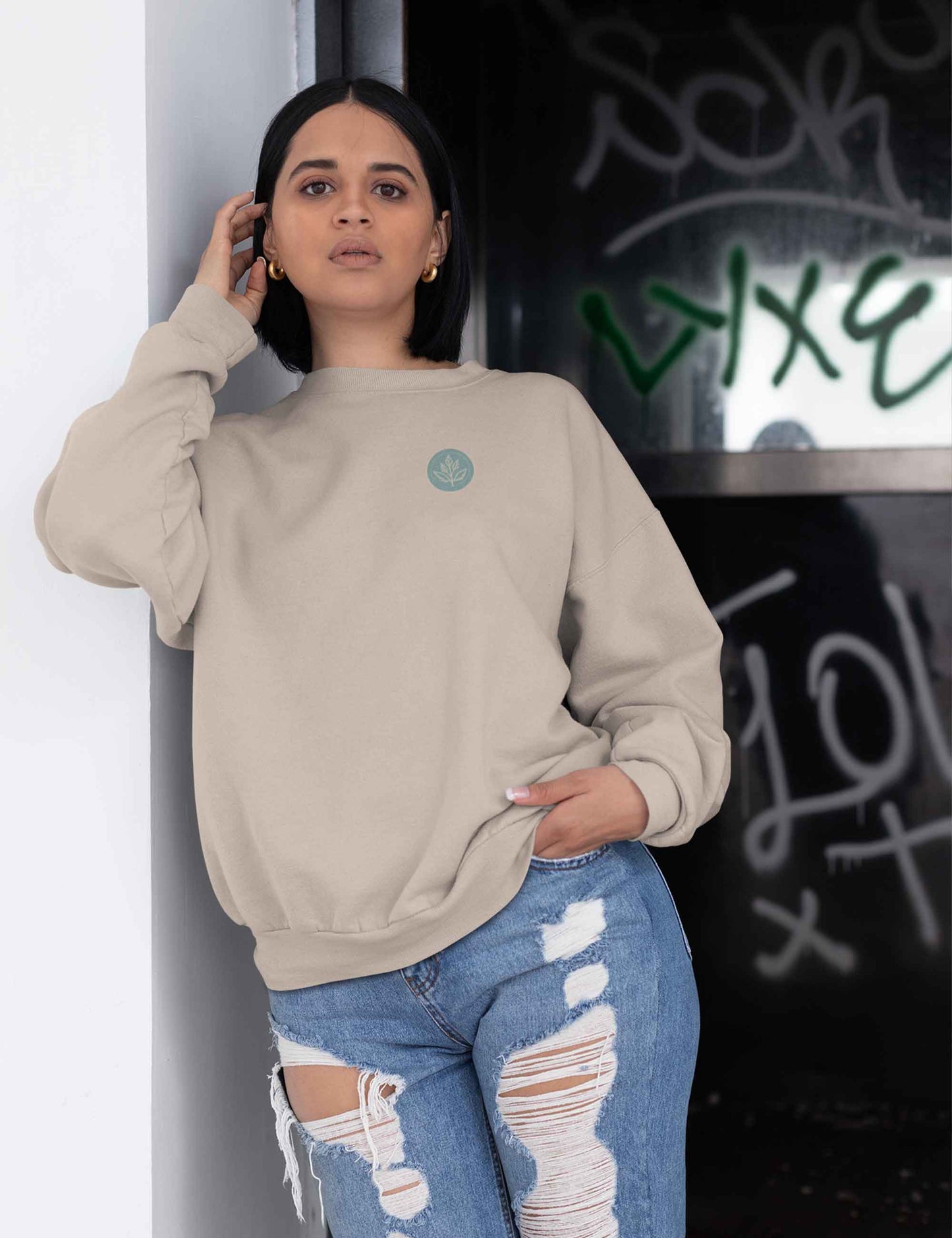 Frau trägt einen bequemen Oversized Sweater mit unserem Ray and Root Logo