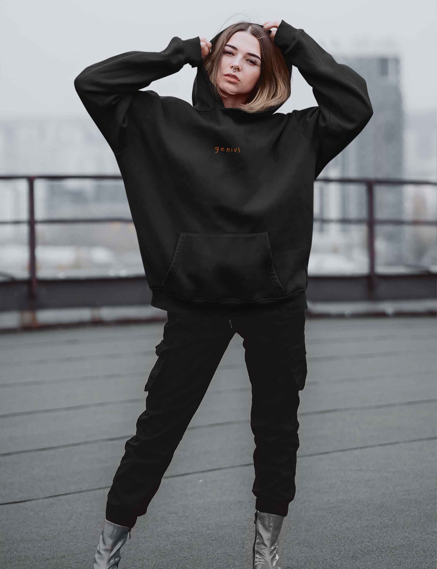 Frau mit lässigem Hoodie mit "genius"-Print in orange auf der Brust