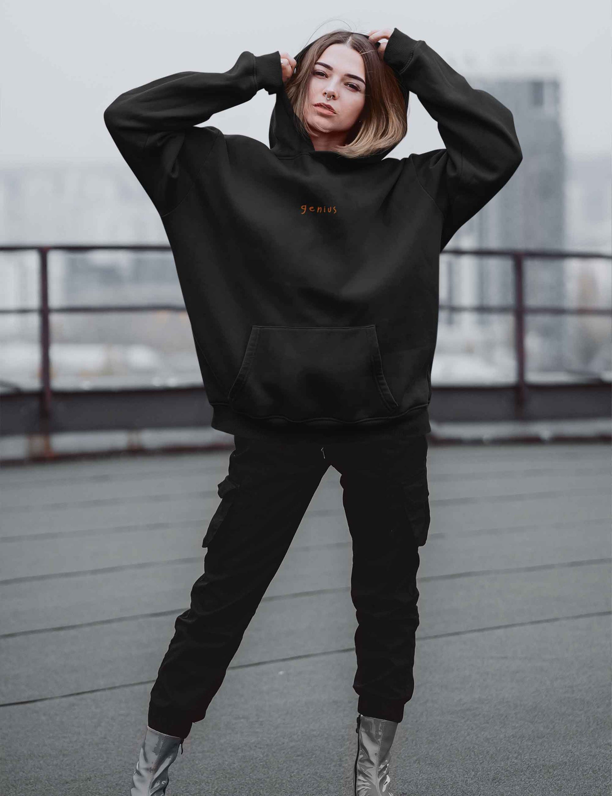 Frau mit lässigem Hoodie mit "genius"-Print in orange auf der Brust